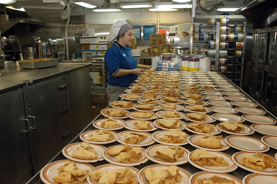 woman in blue polo shirt preparing the food on inline plates