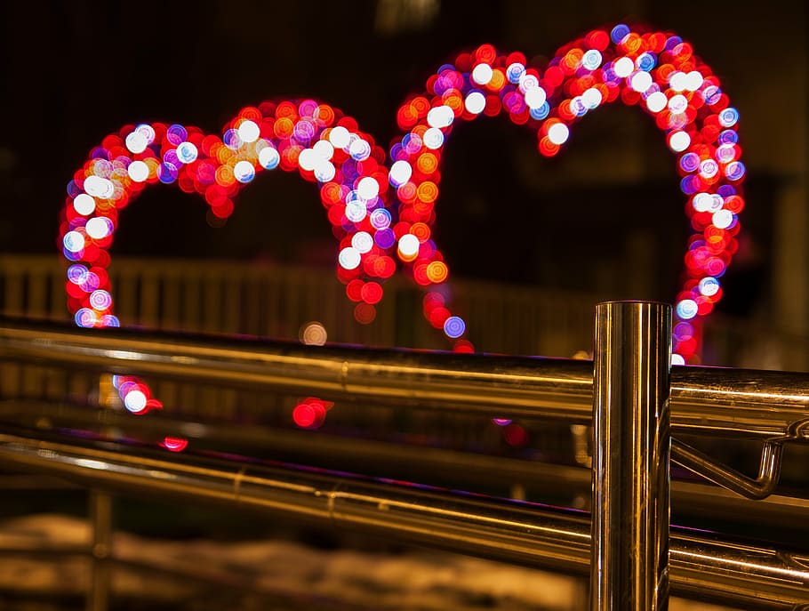 selective focus of gray stainless steel baluster in front on bokeh of heart lights