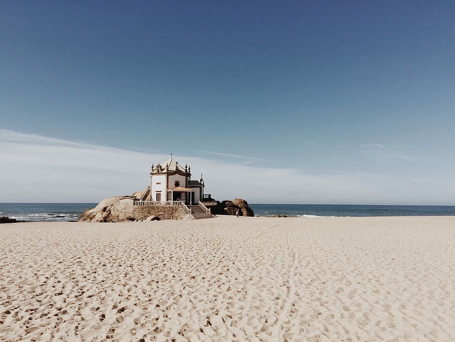white concrete castle on beach, white and brown concrete house near sea under blue sky at daytime HD wallpaper