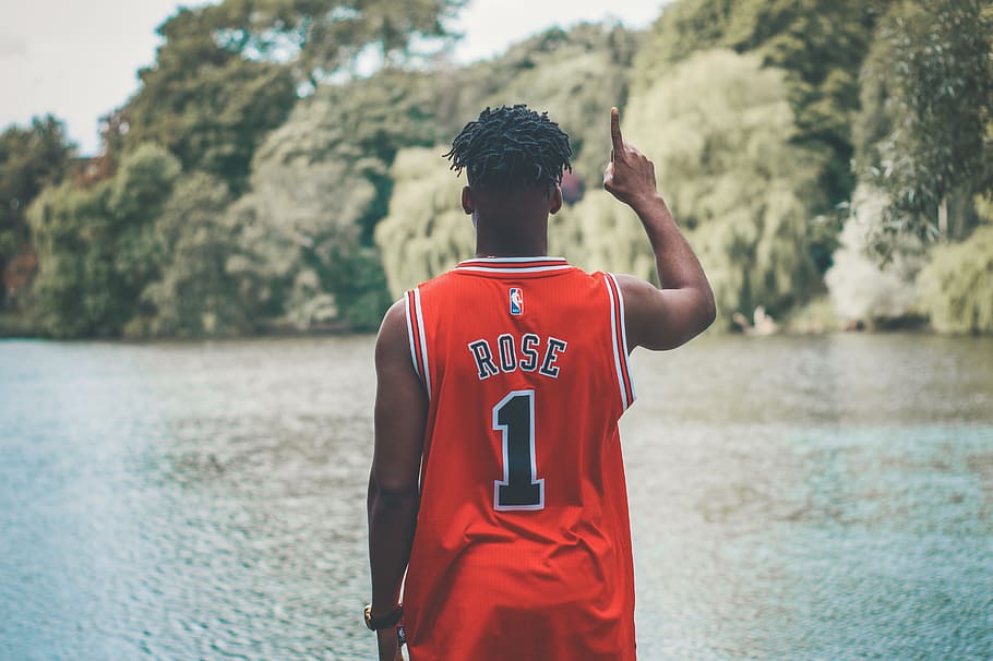 person wearing Derick Rose jersey standing near body of water
