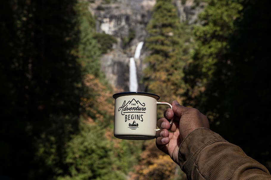 person holding white and brown mug, person holding white and black The Adventure Begins mug HD wallpaper