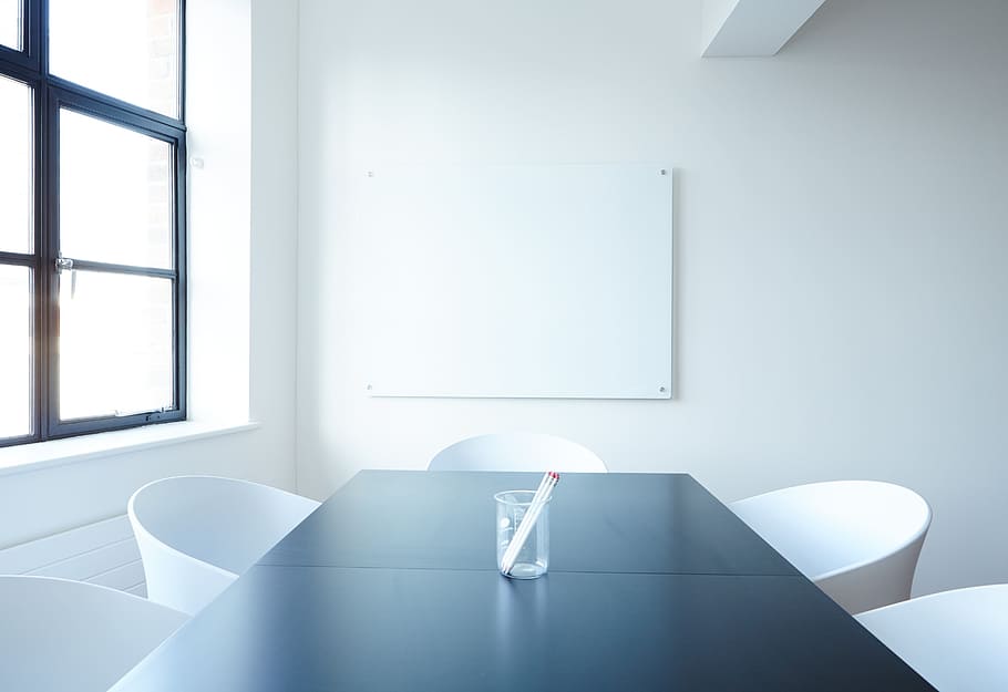 clear glass vase in middle of black wooden table inside white-painted room HD wallpaper