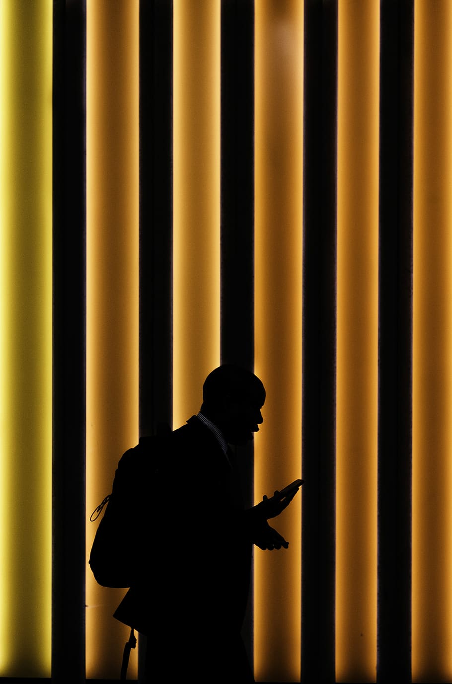 silhouette of man standing on orange and black striped background, silhouette of a man holding a phone, HD wallpaper