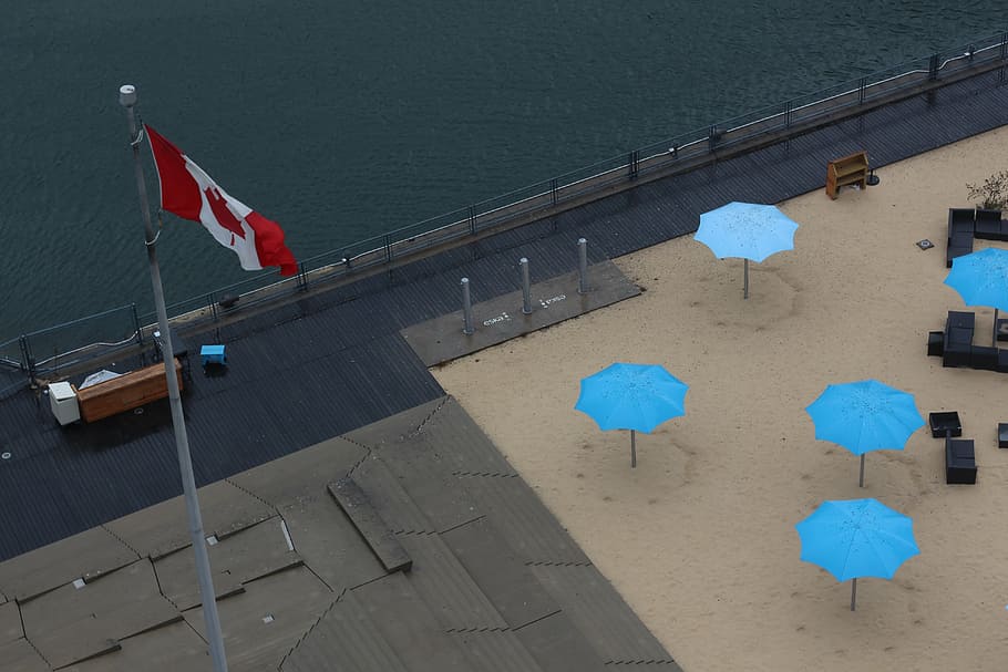 Canada flag on gray pole, shown, cottage, roof, sand, umbrella HD wallpaper