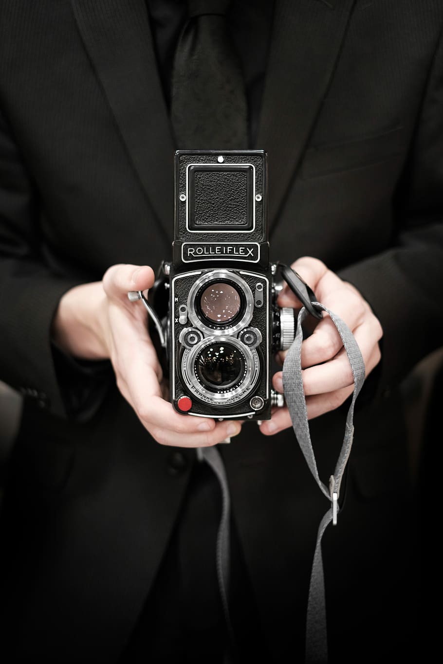 person holding Rolleiflex camera, person holding 2-lens reflex camera