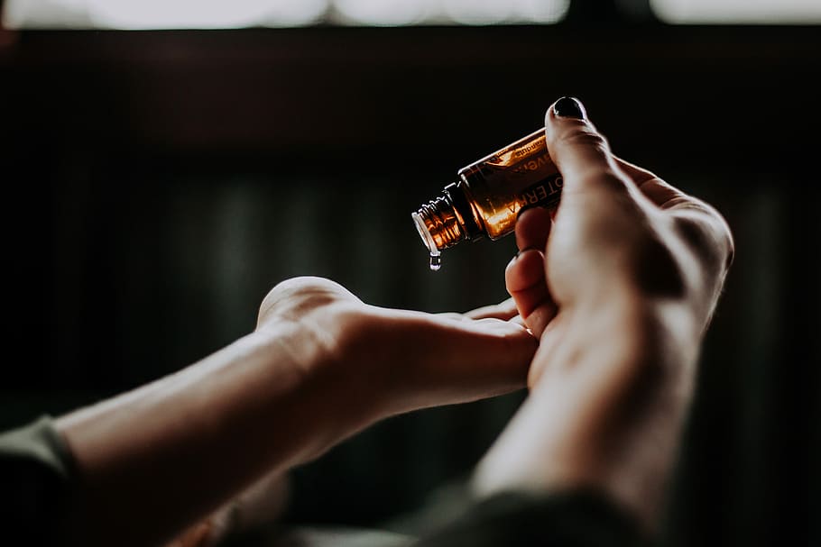 person holding amber glass bottle, person pour a vial bottle on palm HD wallpaper