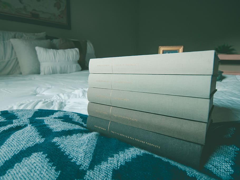 several books on blue bed comforter, five black books on black and gray textile HD wallpaper