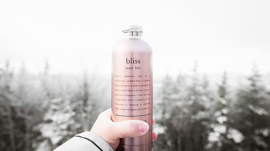 person holding bliss lotion bottle, person holding Bliss labeled bottle HD wallpaper