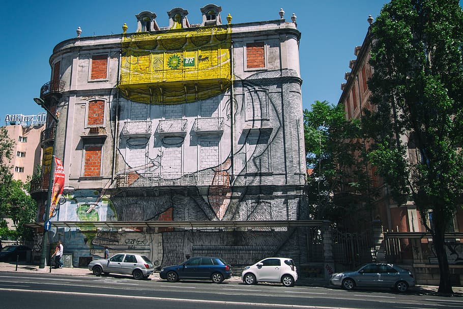 Wide-angle street shot of a building covered in street art. Image captured in Lisbon, Portugal, HD wallpaper