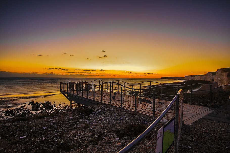 beach dock during golden hour, sunset, ocean, coast, england HD wallpaper