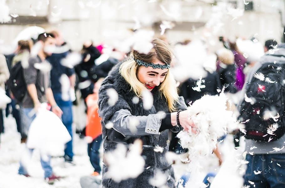 woman playing on the snow, joy, glee, headband, youthful exhuberance