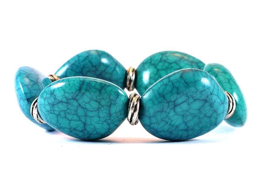 teal stone bracelet on white surface close up photography, jewelry