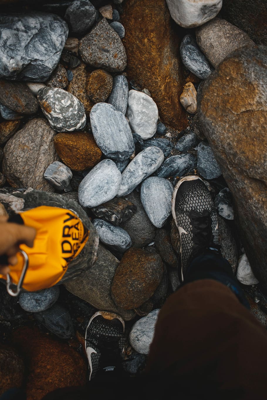 person wearing black Nike shoes, assorted stones, pebble, shingle HD wallpaper