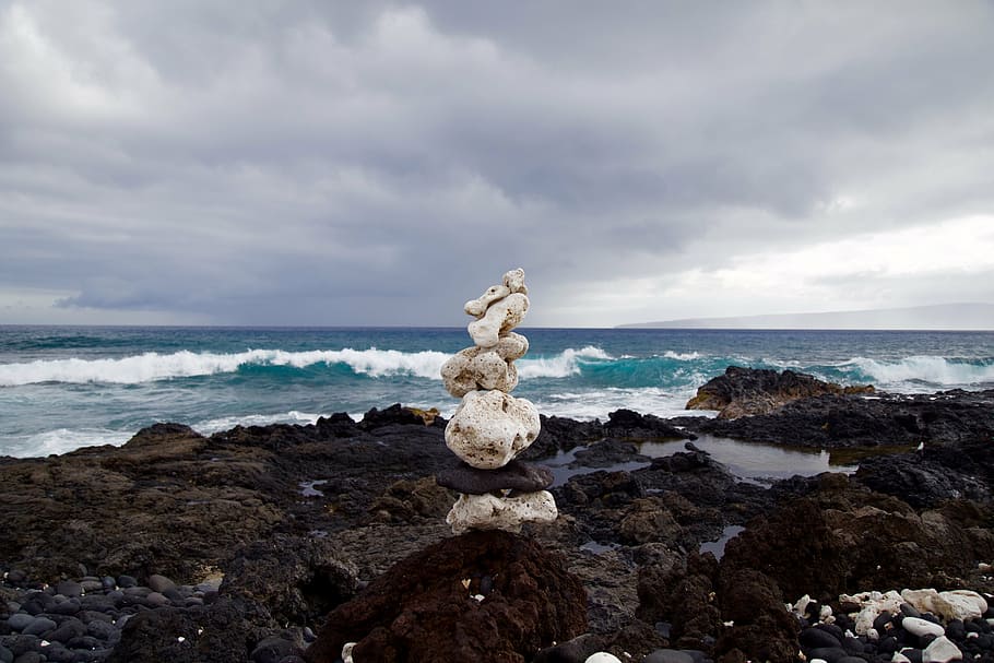 stack of white stones on black surface in front ocean, photo HD wallpaper