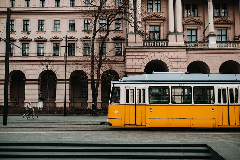 person riding bike near train, building, architecture, tram HD wallpaper