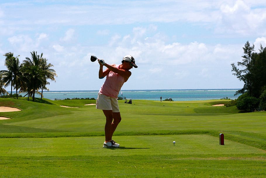 woman in pink tank top with matching white shorts playing a golf under the blue sky during daytime, HD wallpaper