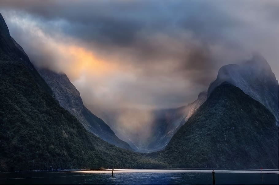 body of water near mountains during daytime photography, photo of mountain at noontime HD wallpaper