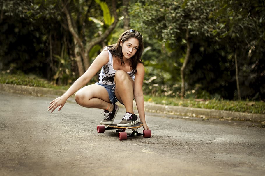 woman in white tank top riding wheel cutout longboard, skateboard