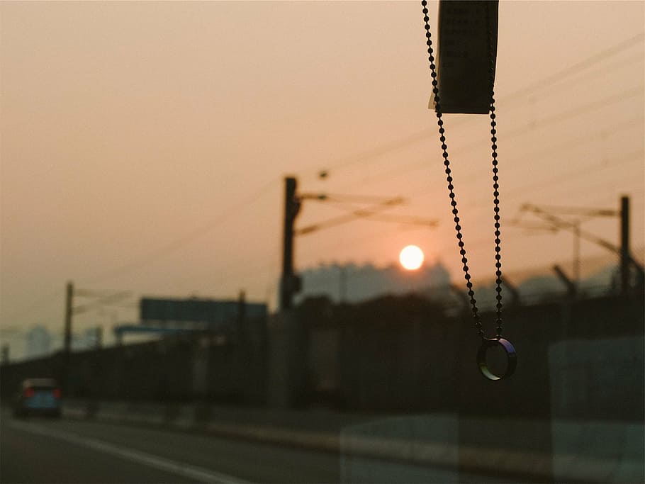 silver-colored necklace hanging inside car front windshield HD wallpaper
