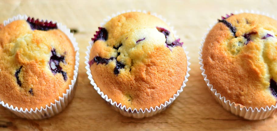 close-up photo of three baked cupcakes, muffins, blueberry muffins