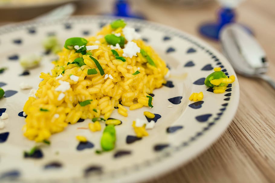 Risotto with broad bean on a cute plate with blue hearts, flowers