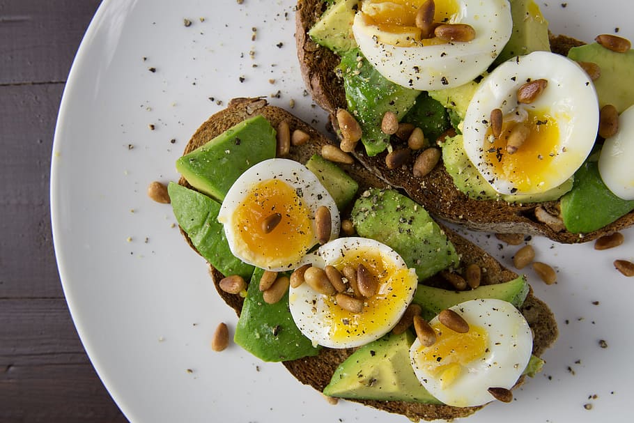 Soft-boiled eggs and avocado on toasted walnut bread, food/Drink
