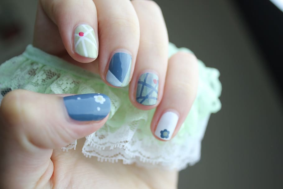 woman showing blue, white, and green nail manicure, nail art