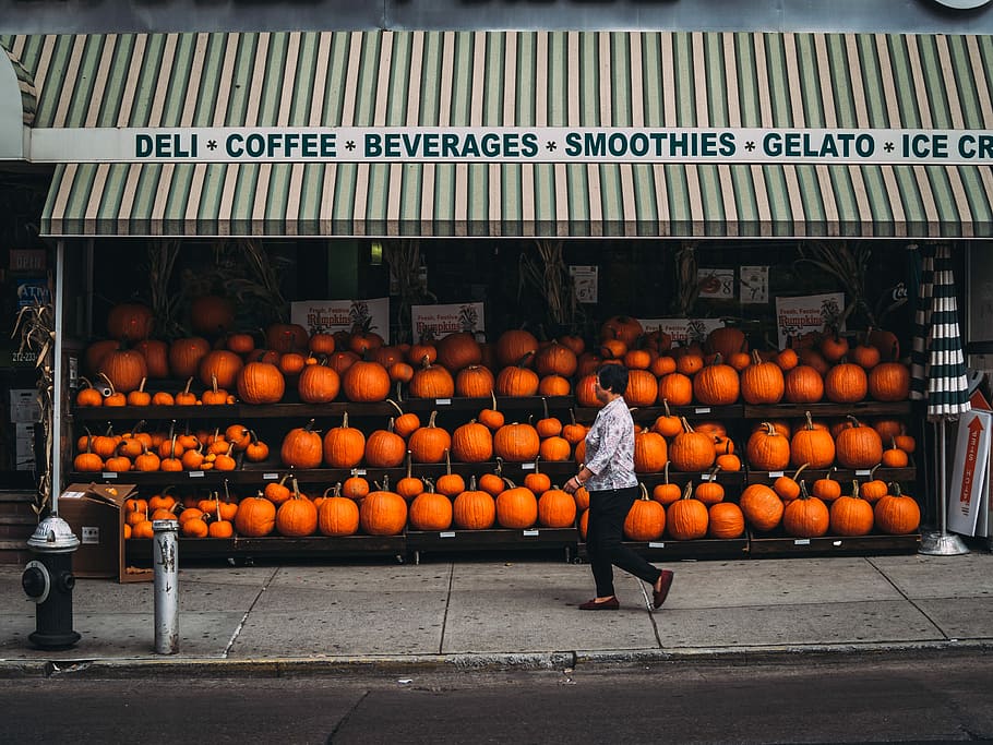 woman walking along pumpkin store, woman walking on pedestal lane, HD wallpaper