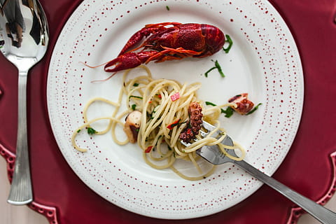 Fancy dinner with seafood pasta, crayfish and red wine by the table decorated with roses HD wallpaper