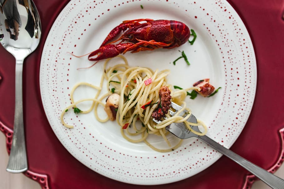 Fancy dinner with seafood pasta, crayfish and red wine by the table decorated with roses HD wallpaper