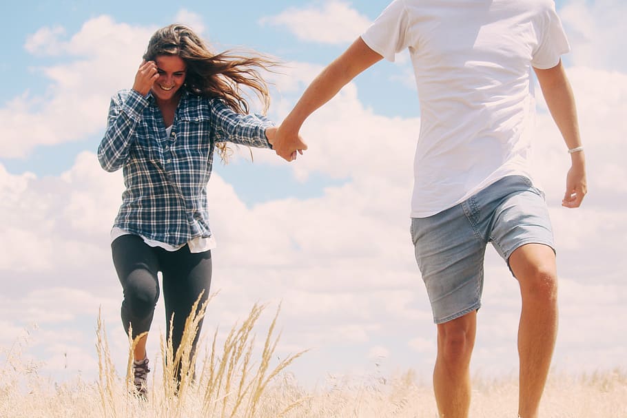 man wearing white t-shirt holding the hand of the woman wearing blue and white plaid dress shirt HD wallpaper