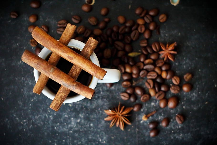 shallow focus of brown coffee beans beside white ceramic mug HD wallpaper