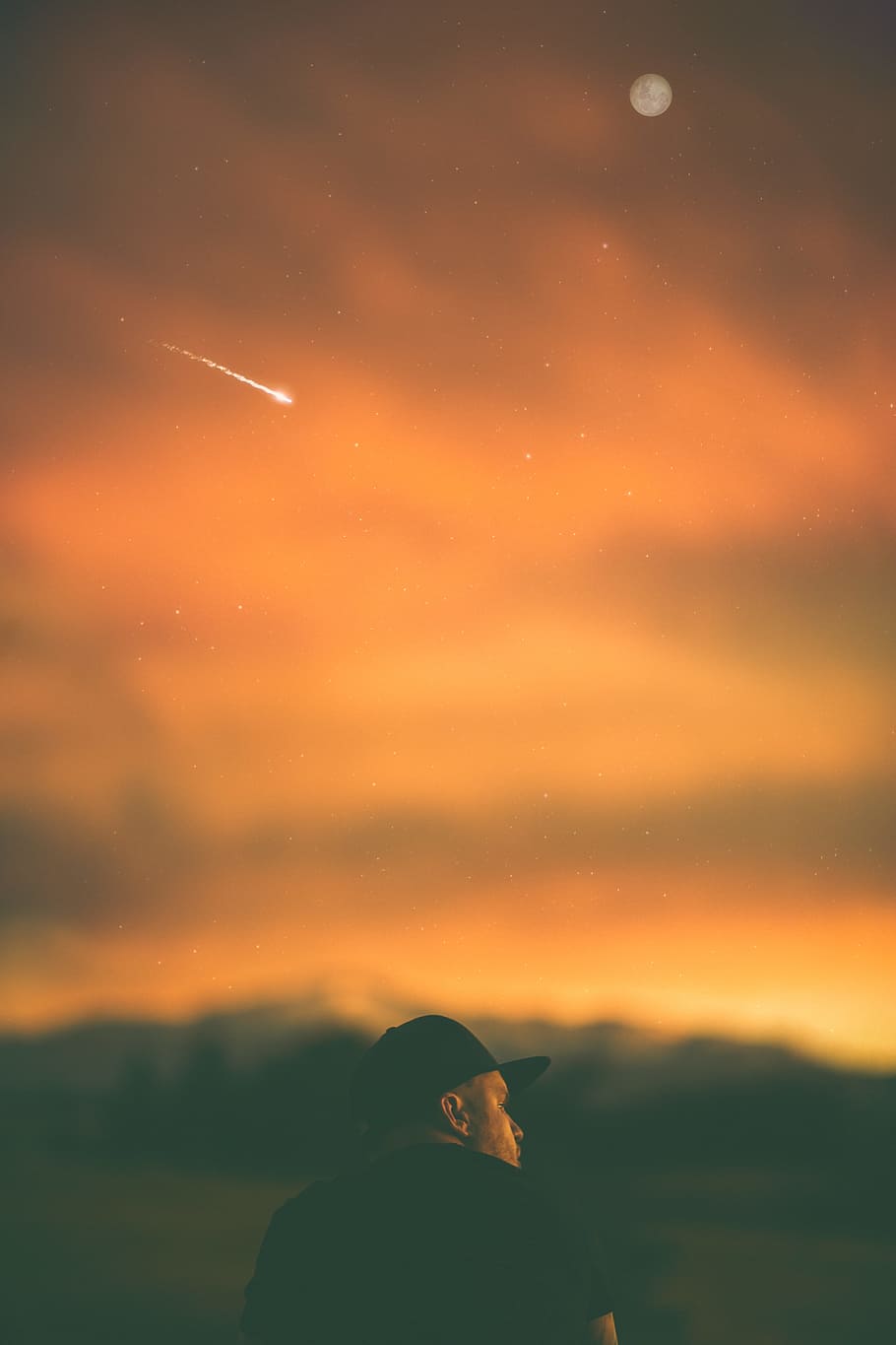 man wearing black fitted cap under orange clouds, man in black cap sitting on ground during middle hour HD wallpaper