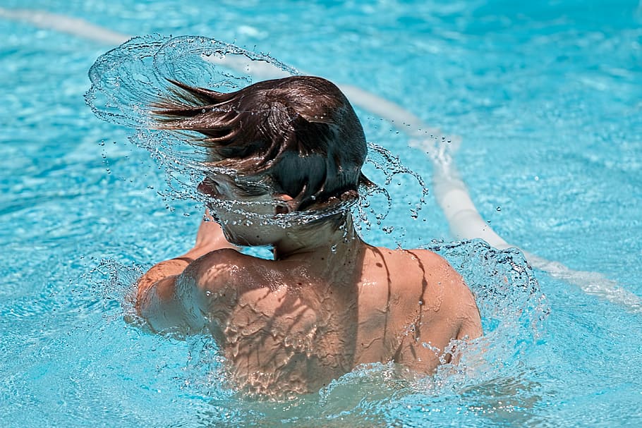 boy with black hair spinning head in pool, swimming, splash, swimmer