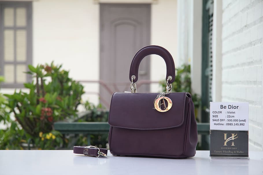 purple leather two-way bag near wall, dior, xịn, focus on foreground