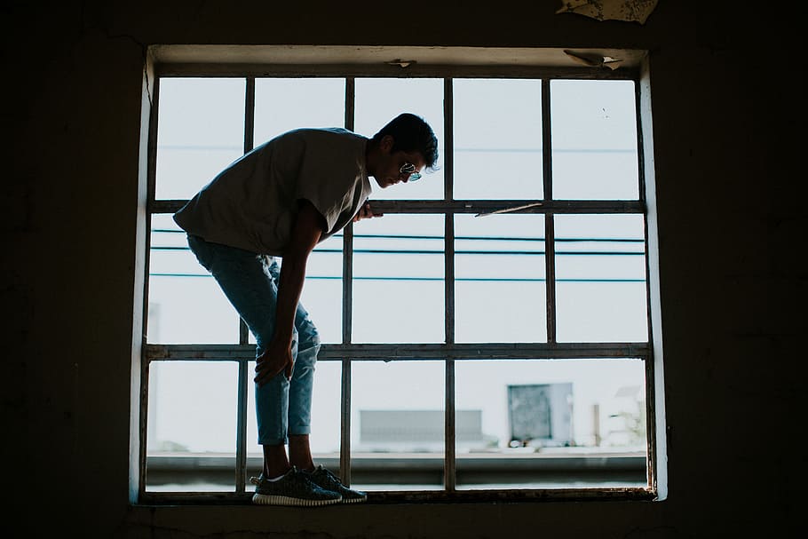 photography of man standing on window during daytime, indoors HD wallpaper