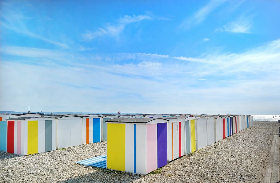 multicolored sheds near shore during day, assorted-color sheds under blue and white clear sky at daytime