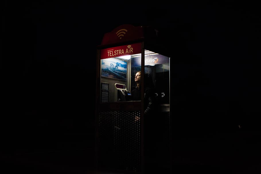 man inside telephone booth, photo of man inside telephone booth