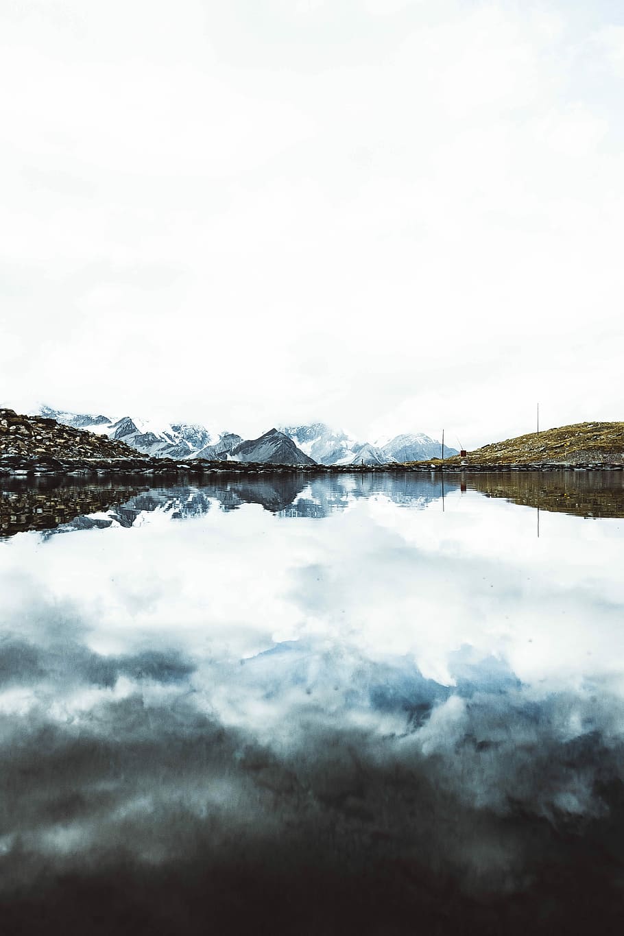 lake and mountains, calm lake towards snow covered mountains under white sky HD wallpaper