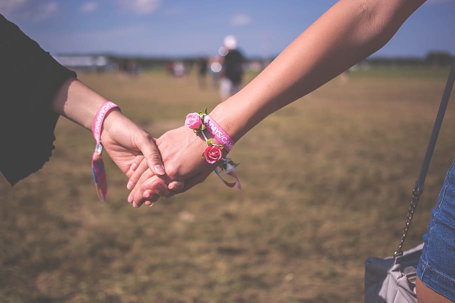 two person holding each other hands, two women holding hands together on field during daytime, HD wallpaper