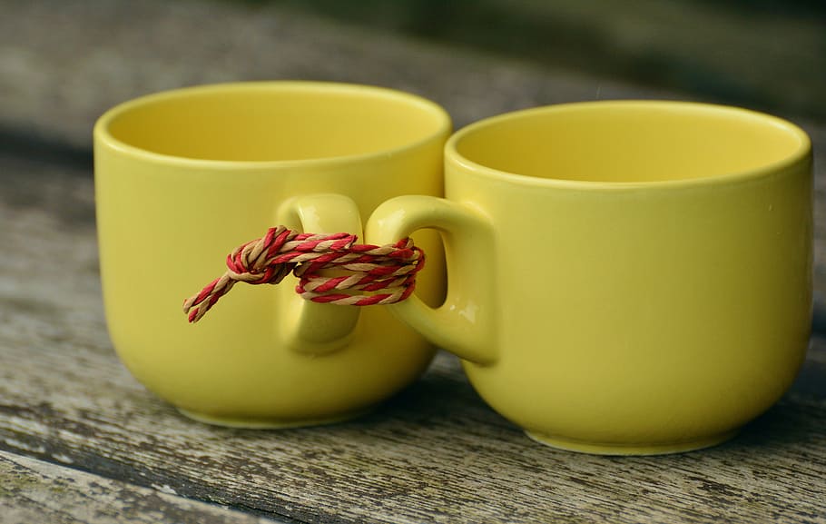 two yellow ceramic teacups tied together, for two, partnership HD wallpaper