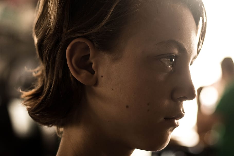 selective focus of woman's face, emotion, sunlight, people, sunset