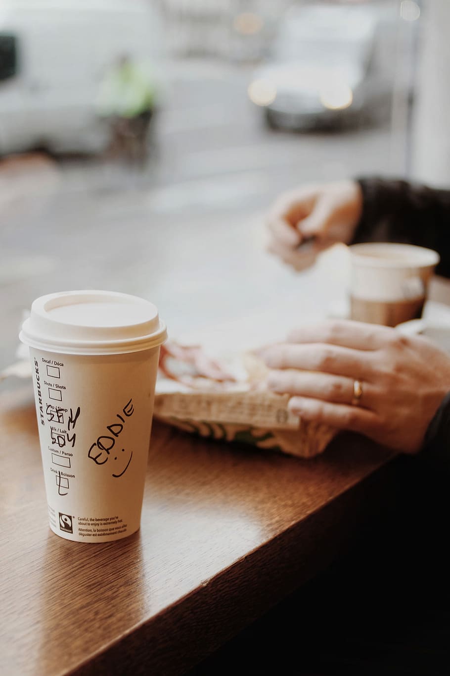 white disposable cup near person's hand selective focus photography HD wallpaper