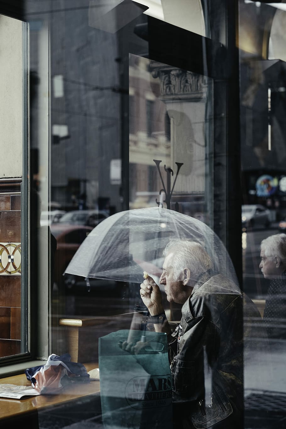 Crossing Paths, man carrying umbrella near glass panel during daytime HD wallpaper