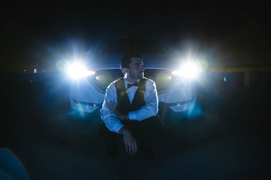white car at the back of sitting man, man sitting in front of white car HD wallpaper