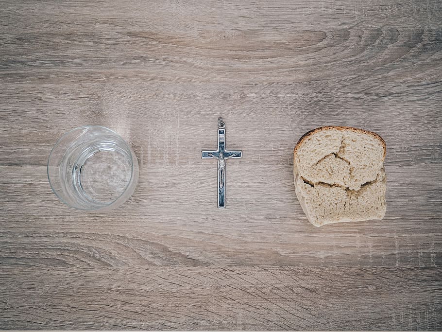 closeup photo of silver-colored cross pendant beside baked bread, clear drinking glass beside black crucifix, HD wallpaper