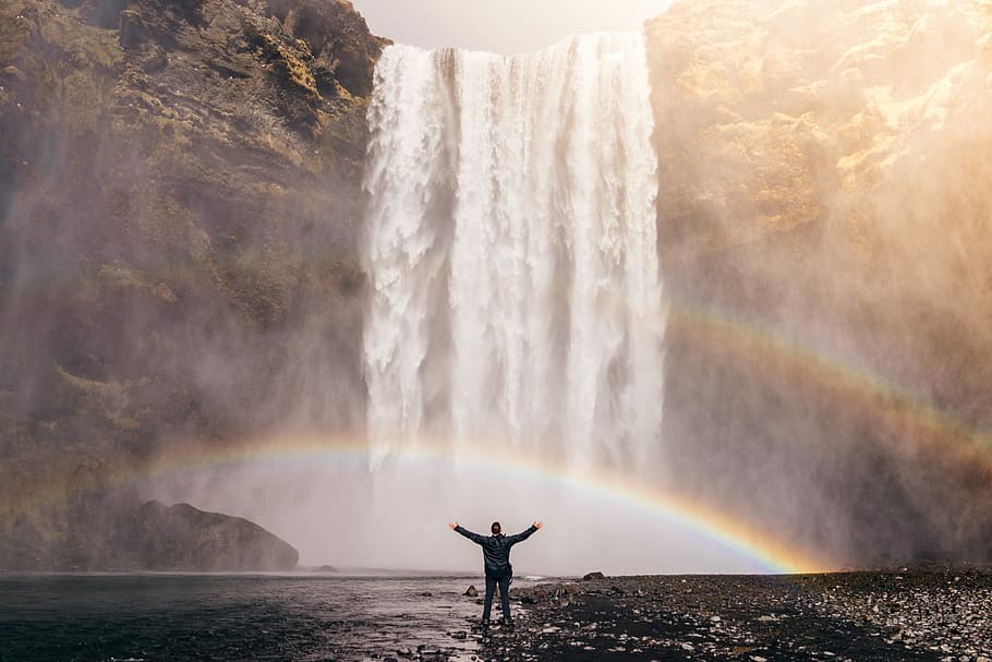 man in black long sleeve shirt in front of waterfalls, brown HD wallpaper