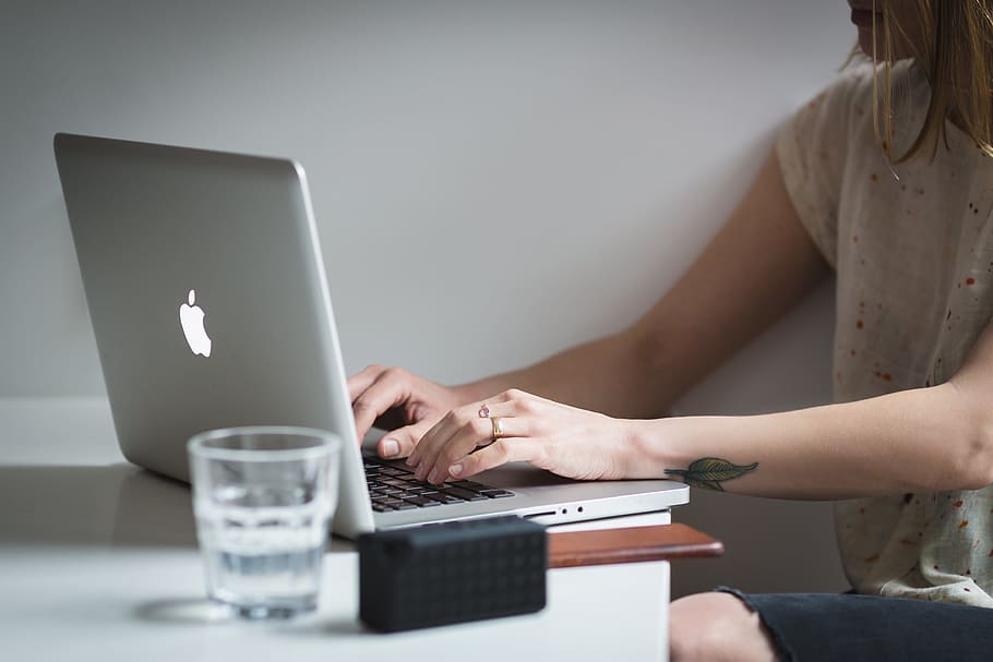 woman using her MacBook near glass of water, laptop, apple HD wallpaper