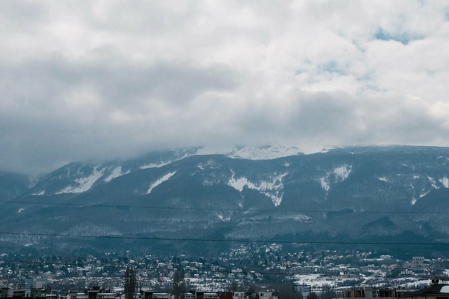 aerial photography of city with glacier mountain background at day time HD wallpaper