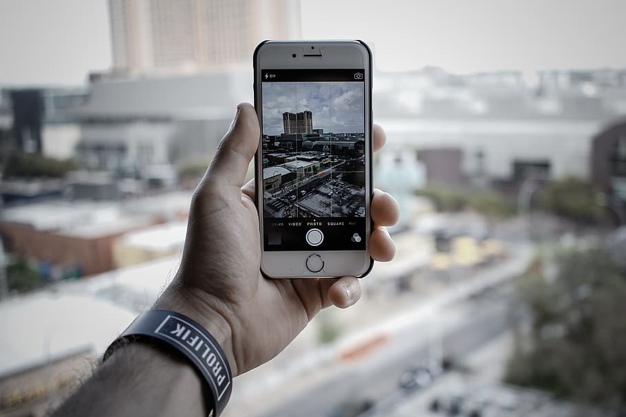 person taking photo of buildings with silver iPhone 6, camera HD wallpaper